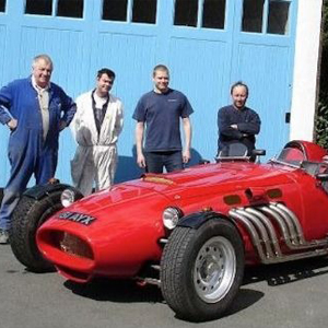 old racing car with staff behind